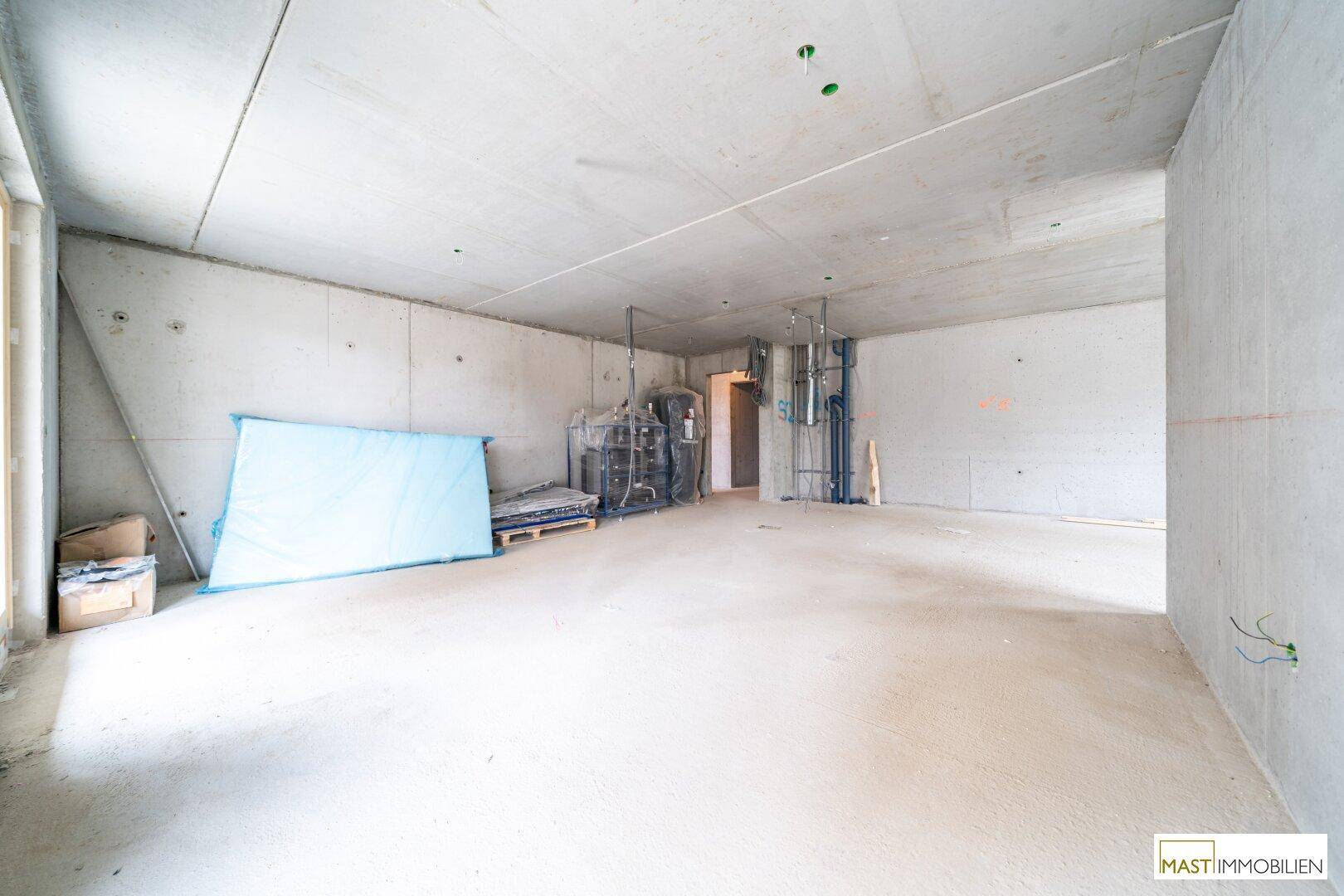 Geräumiger Rohbau mit Betonwänden und Decken, bereit für den weiteren Innenausbau.