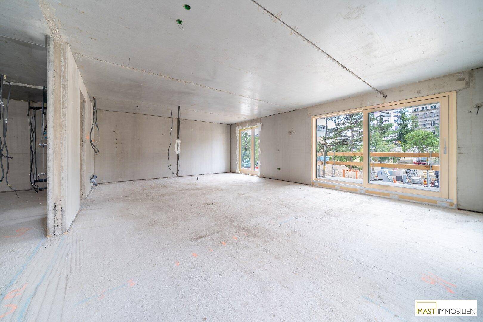 Geräumiger Rohbau mit großen Fensterfronten, die viel natürliches Licht hereinlassen.