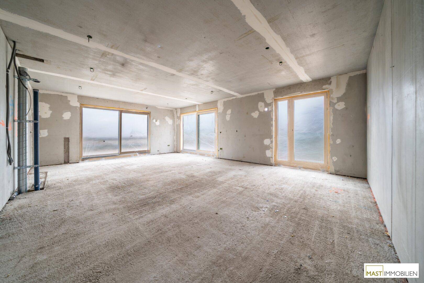 Geräumiger Rohbau mit großen Schiebetüren und viel Tageslicht, bereit für den Ausbau.