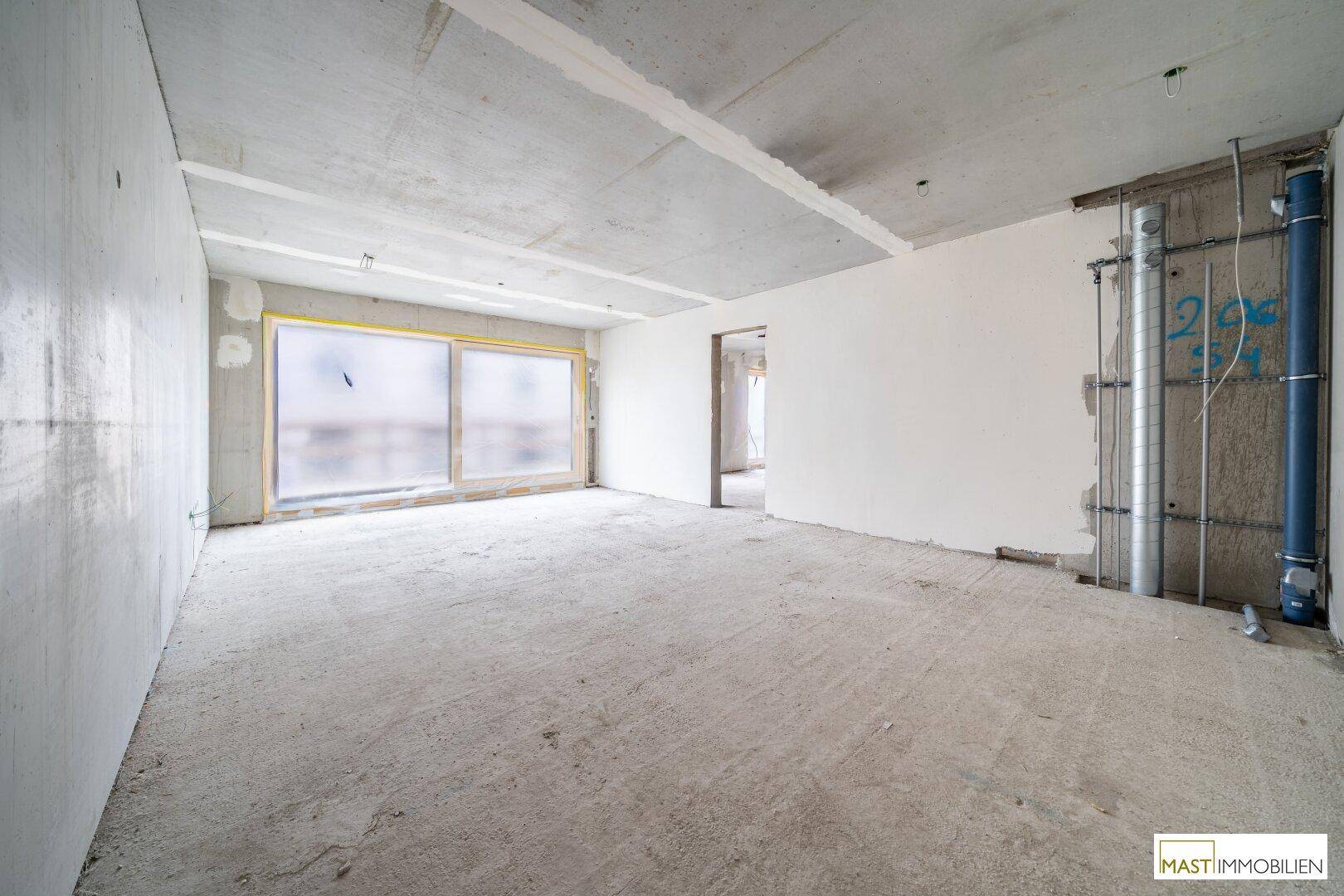 Unfertiger Innenraum mit Betonboden und großen Fensteröffnungen, bereit für den individuellen Ausbau.