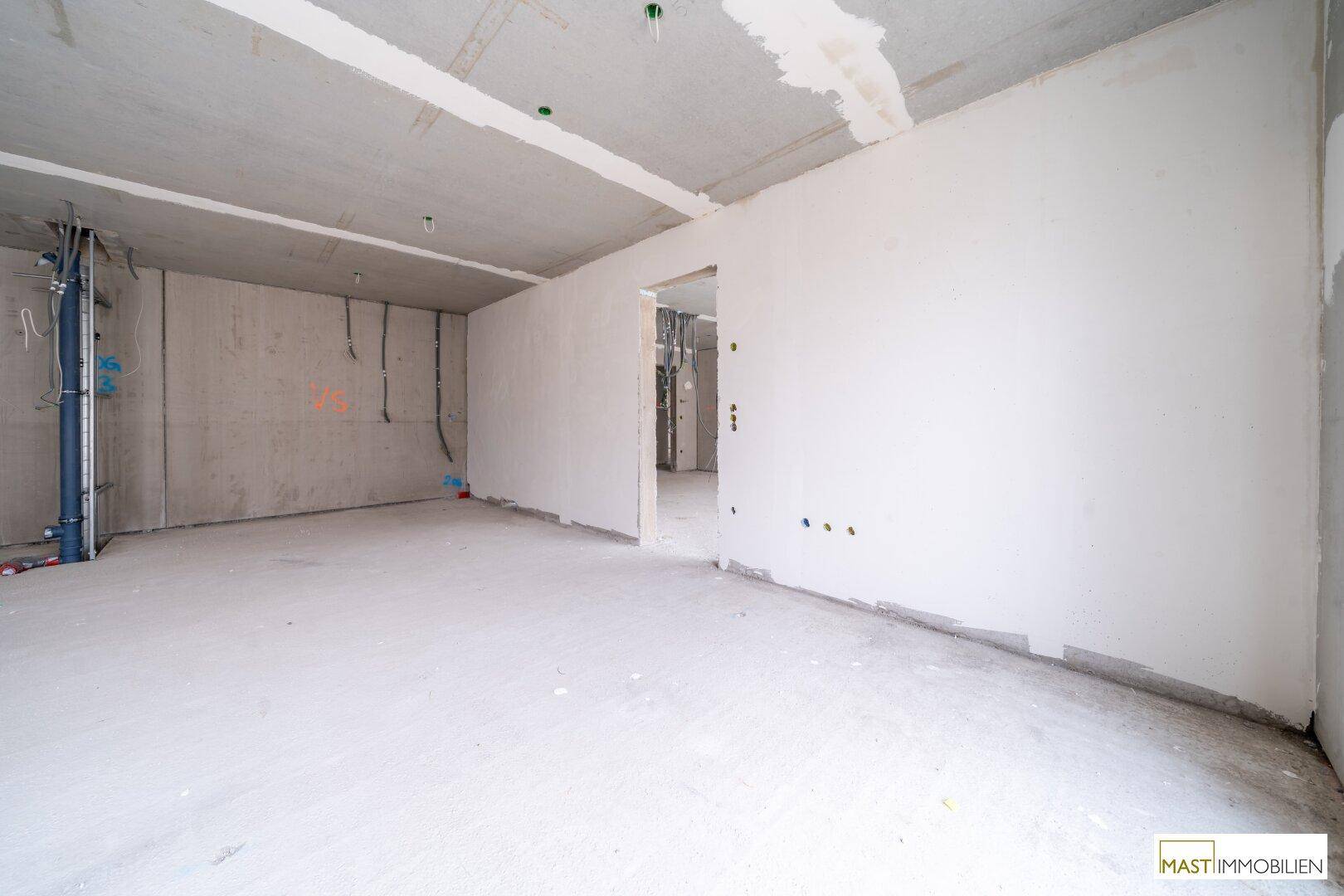 Rohbau-Innenraum mit Betonwänden und Decken, bereit für die Installationen und den weiteren Ausbau.