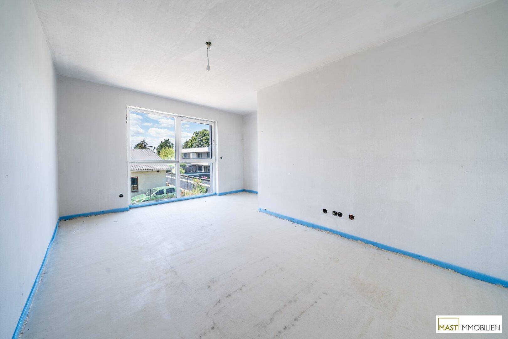 Helles, unfertiges Schlafzimmer mit großen Fenstern, die einen weiten Blick auf die Umgebung bieten.
