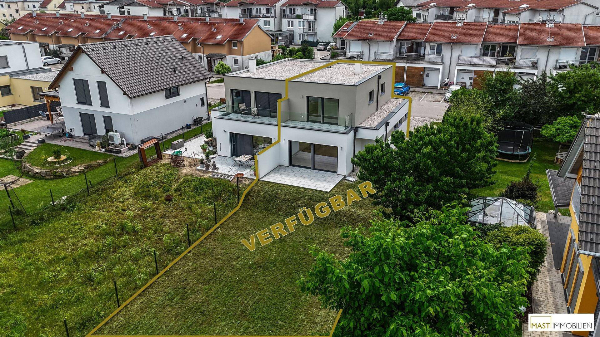 Luftaufnahme des modernen Hauses mit markiertem Grundstück und umliegender Wohnbebauung.