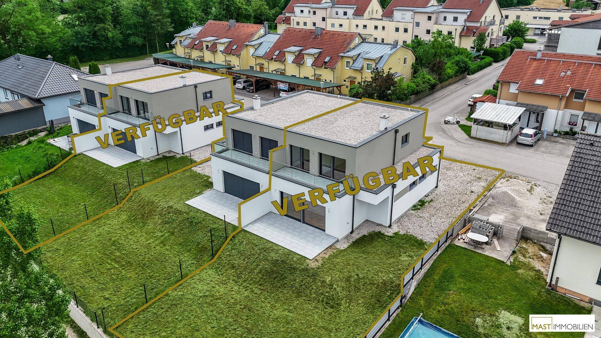 Luftaufnahme von zwei verfügbaren modernen Einfamilienhäusern mit Flachdach und Gärten in einer Wohnsiedlung.