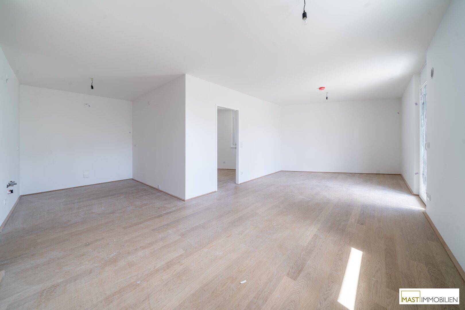 Geräumiges, helles Wohnzimmer mit neuem Holzparkettboden und viel Potenzial zur Gestaltung.