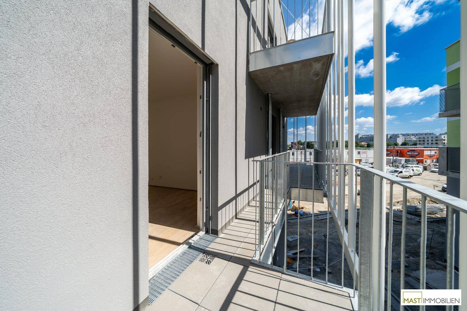 Geräumiger Balkon mit Metallgeländer und Blick auf die Umgebung, ideal für entspannte Stunden.