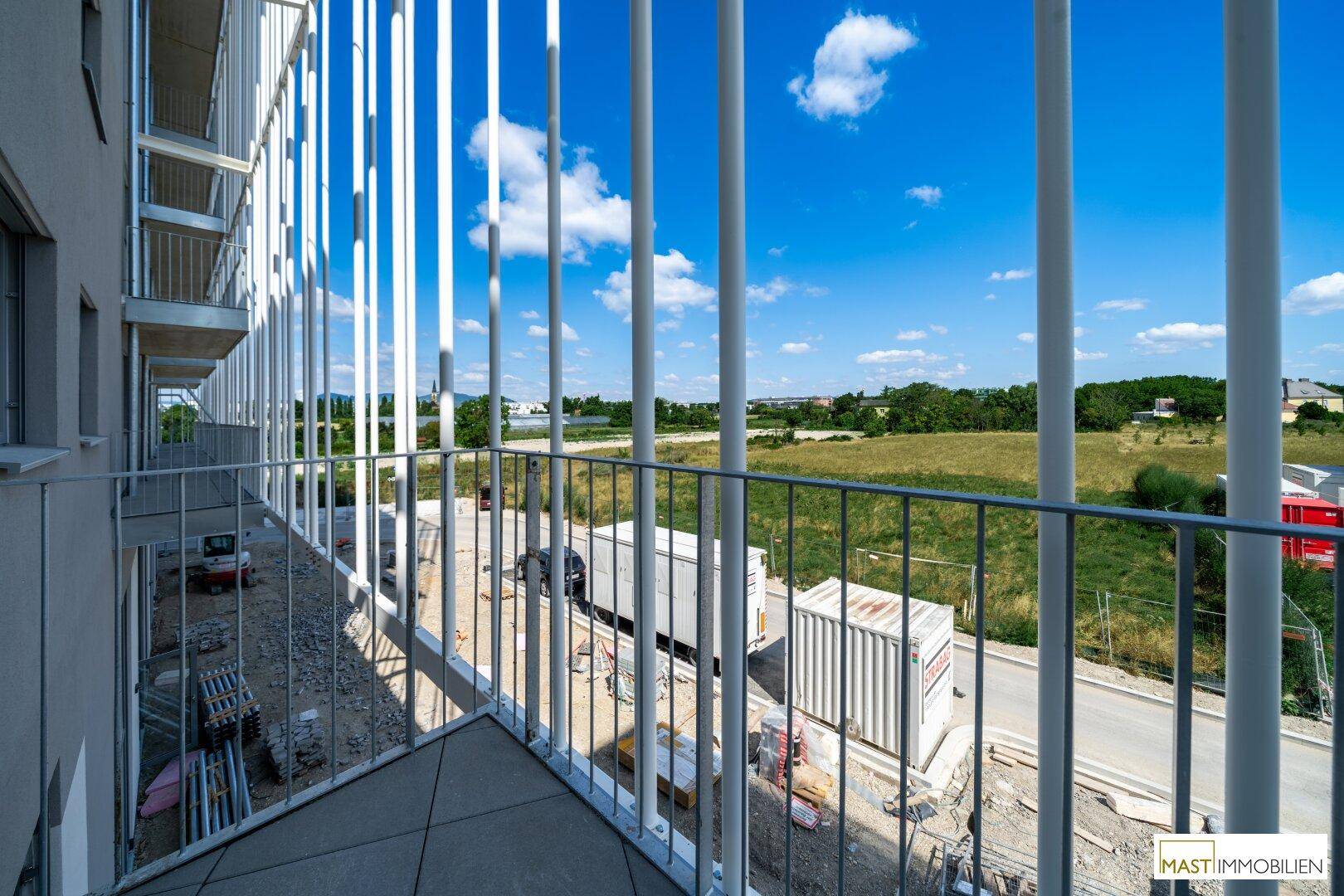 Balkon mit weitem Blick über grüne Felder und die umliegende Landschaft, ideal zum Entspannen.