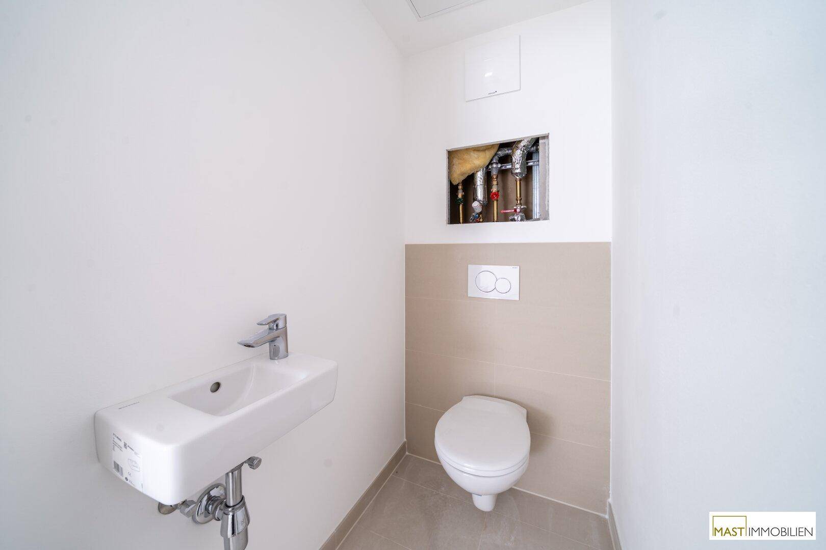 Kompaktes Gäste-WC mit wandhängender Toilette und kleinem Waschbecken, funktional und modern.