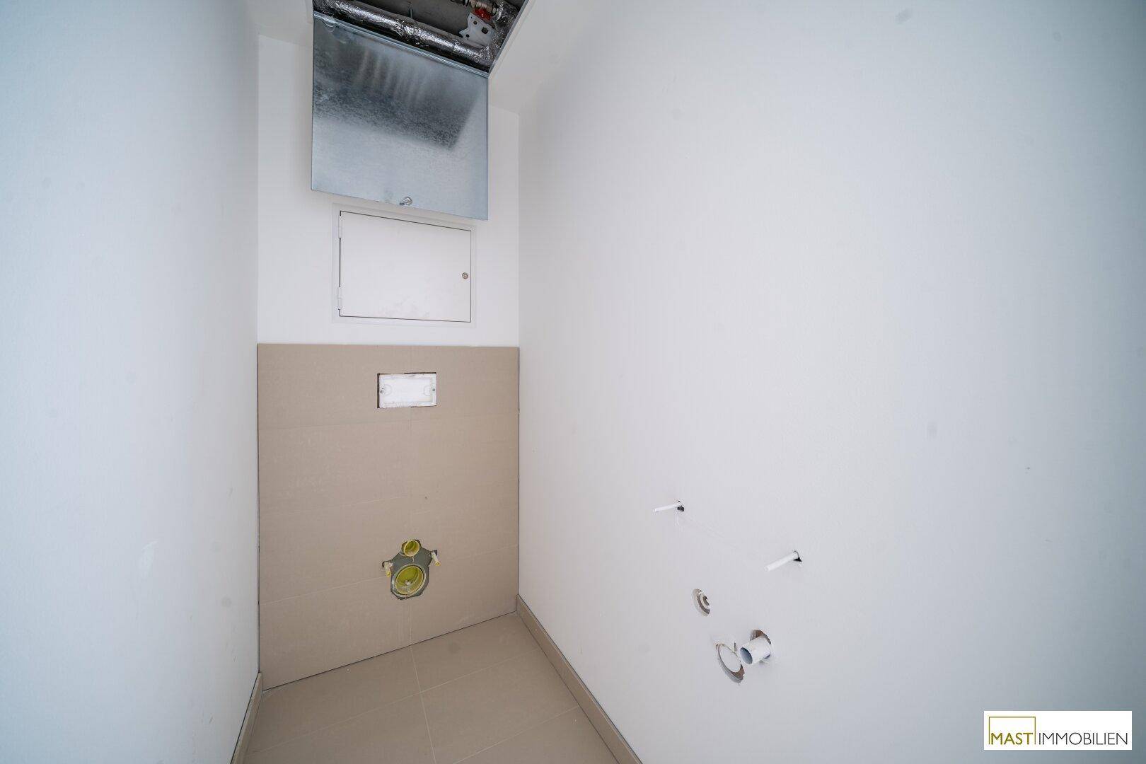 Kleiner Raum für ein WC mit vorbereiteten Anschlüssen und Lüftungssystem an der Decke.