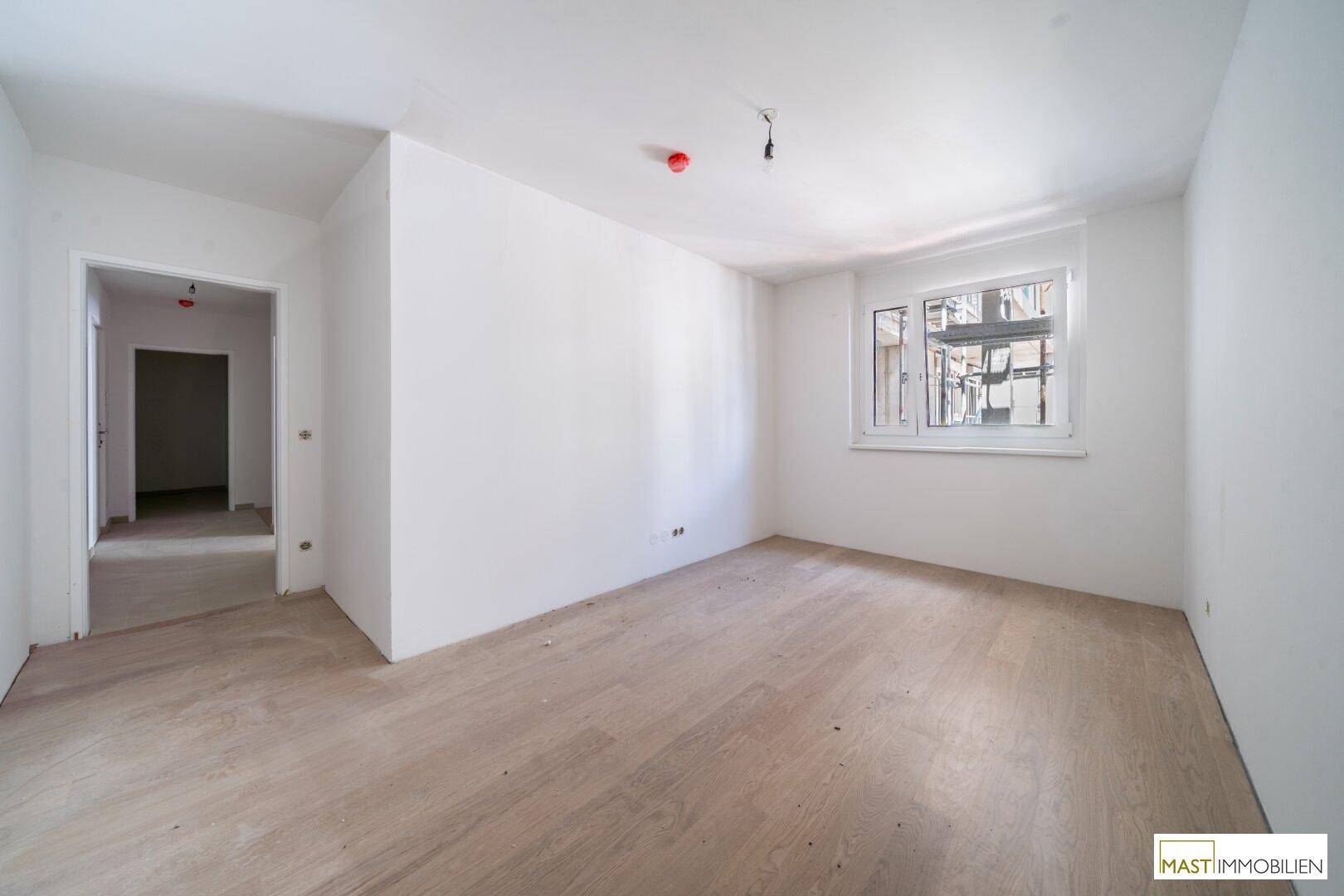 Freundliches Zimmer mit Laminatboden und einem Fenster, ideal als Schlaf- oder Arbeitszimmer.