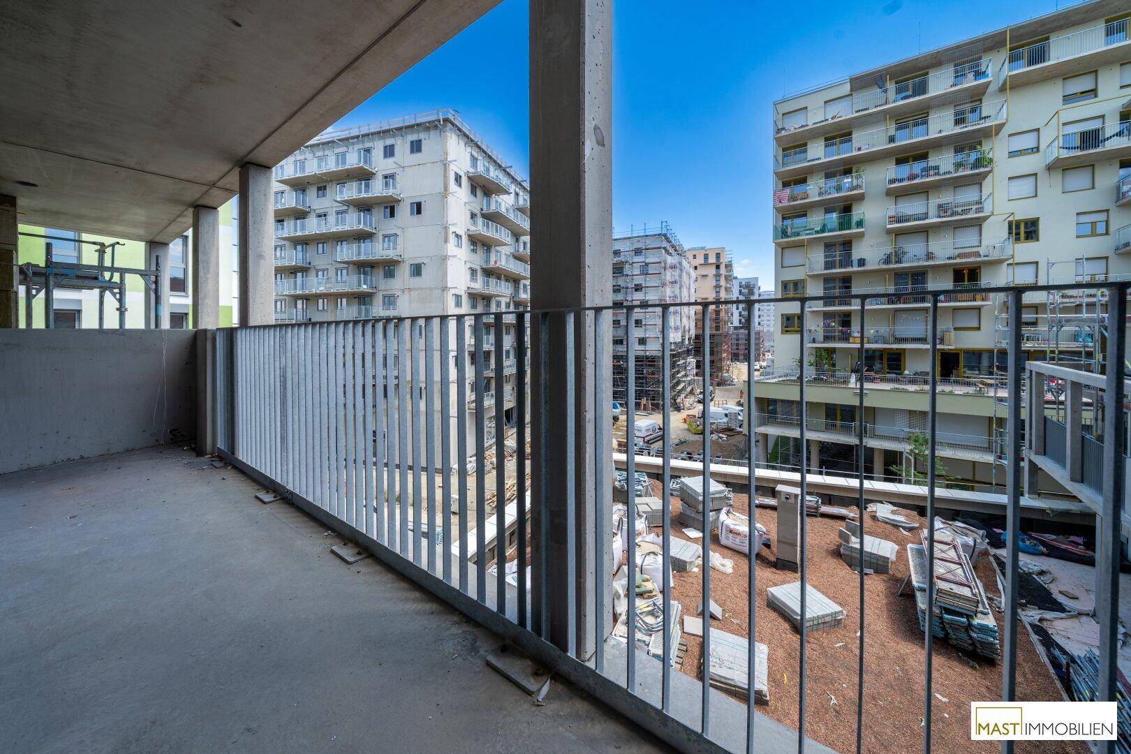 Balkon mit Blick auf die umliegenden Neubauten und eine Baustelle, typisch für ein neues Stadtviertel.