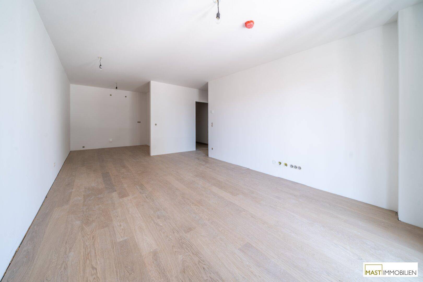 Großer, heller Wohnbereich mit modernem Laminatboden und viel Potenzial zur Gestaltung.