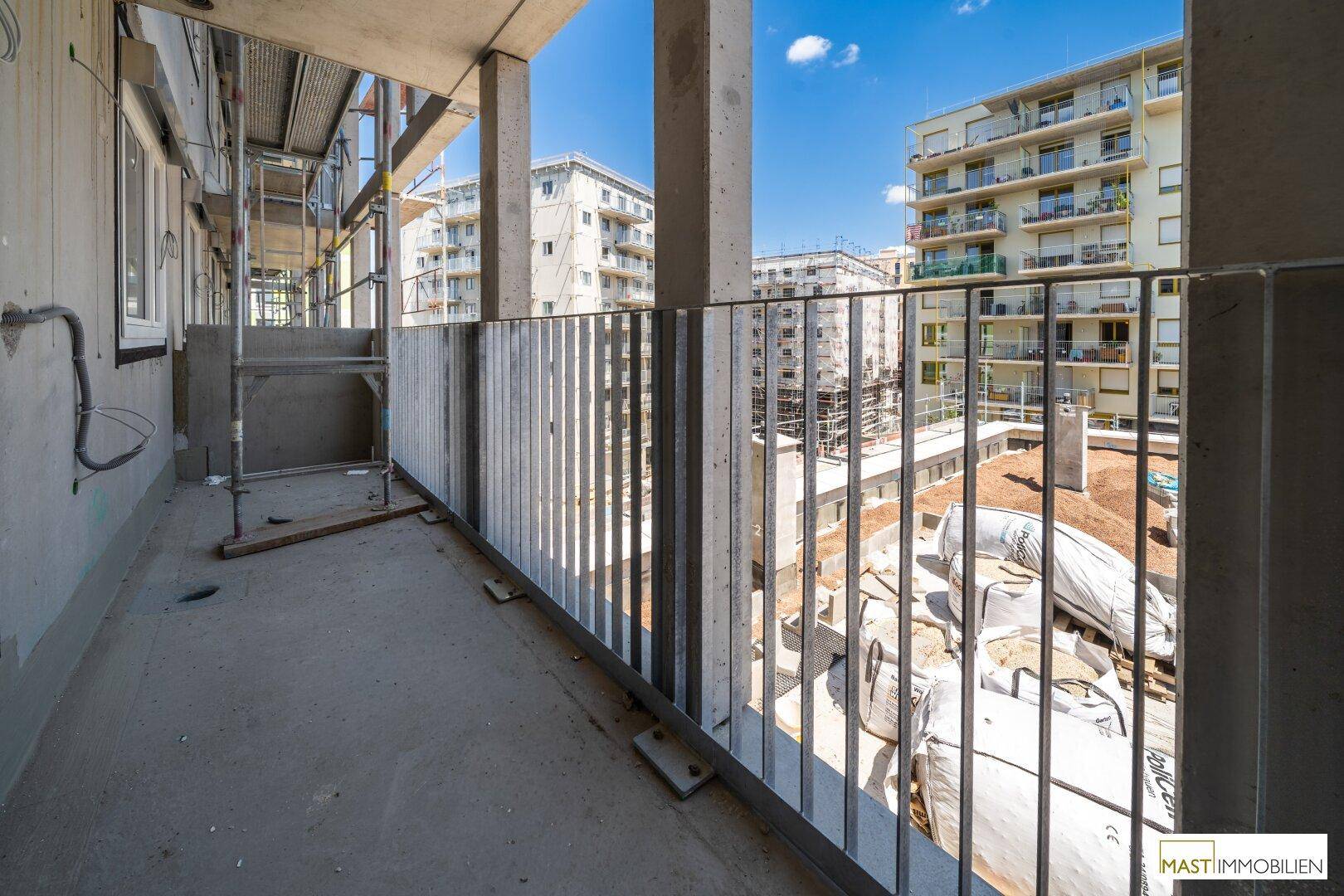 Geräumiger Balkon im Bau mit Blick auf die umliegenden Wohngebäude und Baustellen.