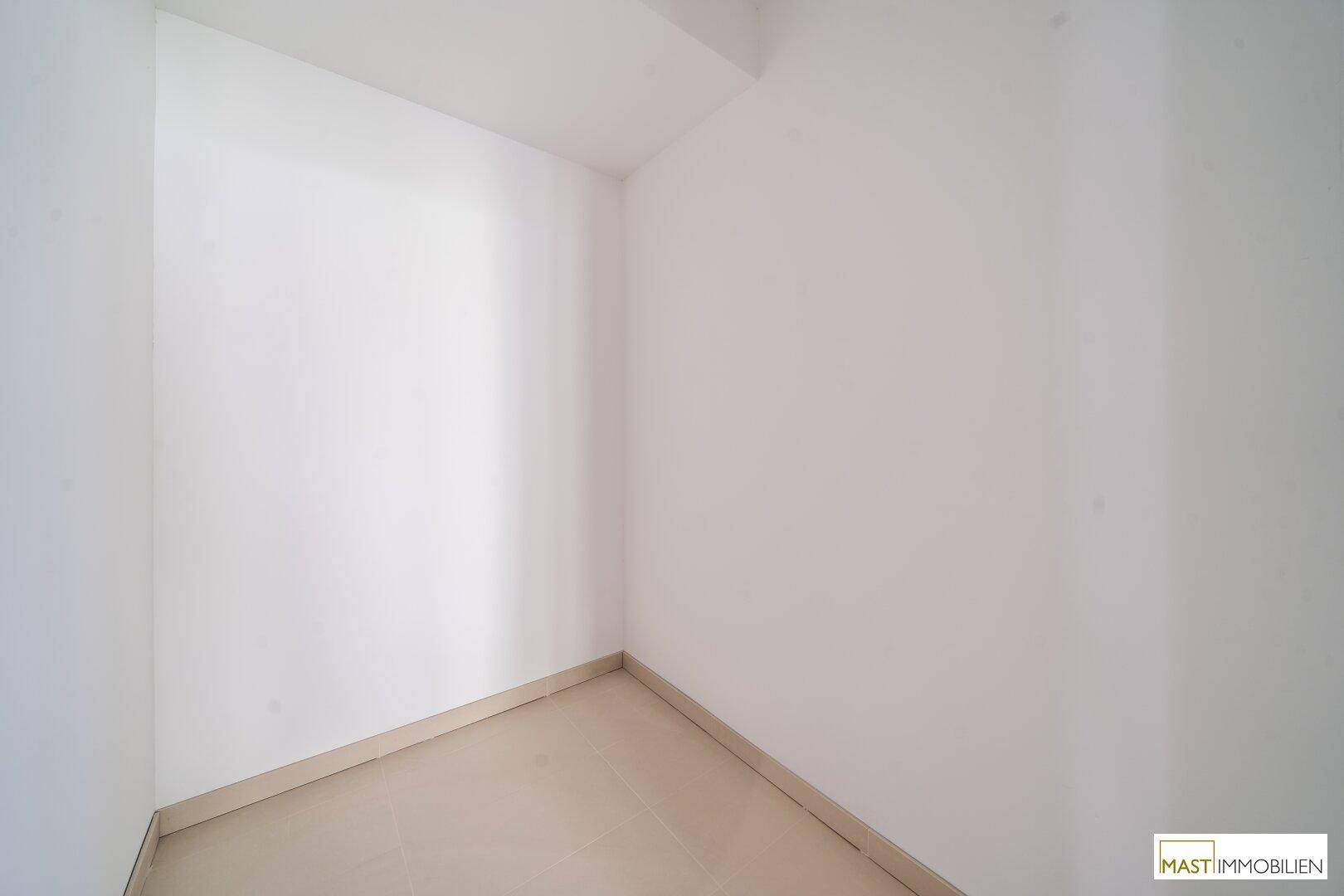 Kleiner, leerer Raum mit Fliesenboden, ideal als Abstellraum oder Speisekammer nutzbar.