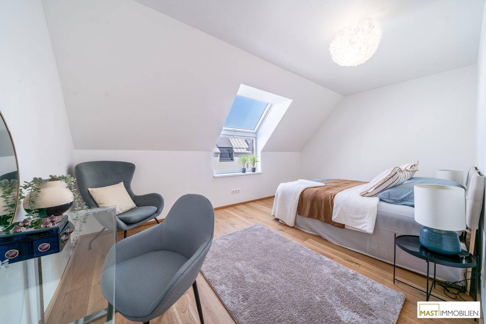 Lichtdurchflutetes Schlafzimmer mit Holzboden, modernem Bett und einem großen Dachfenster.