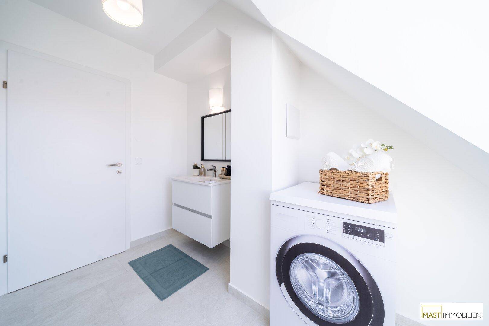 Praktischer Hauswirtschaftsraum mit Waschmaschine, Waschbecken und Spiegelschrank.