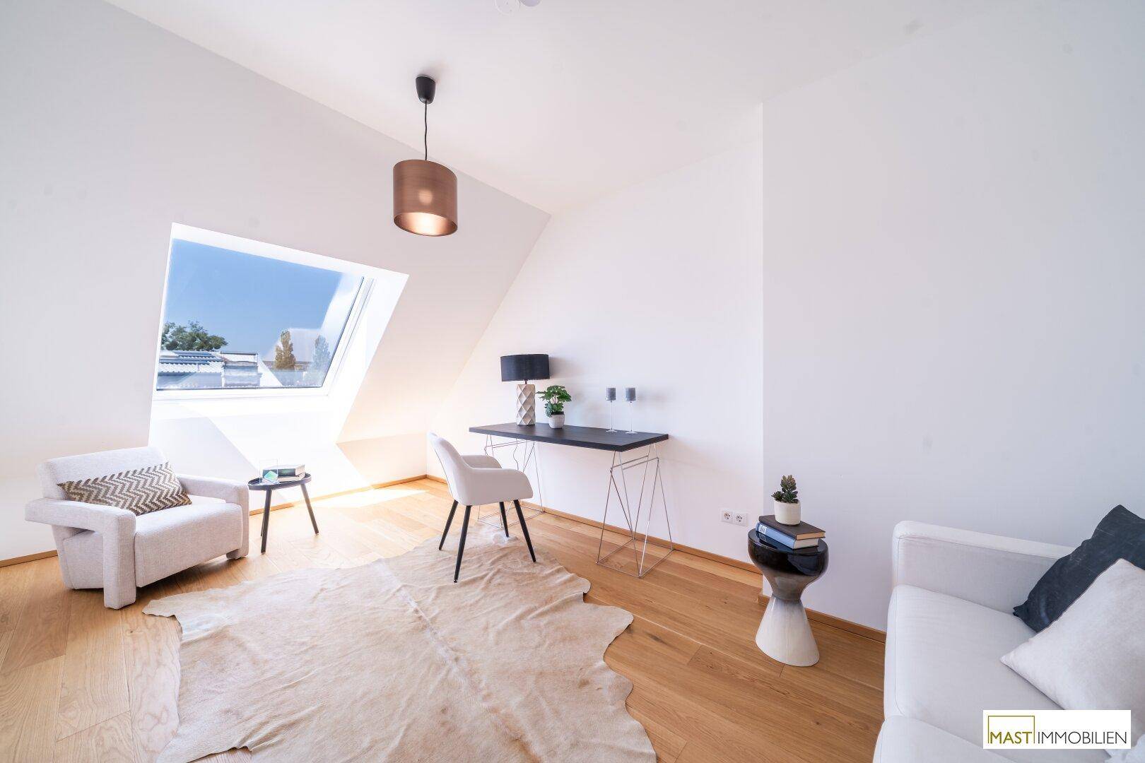 Helles Arbeitszimmer mit Dachschräge, Holzboden und großem Dachfenster für viel Tageslicht.