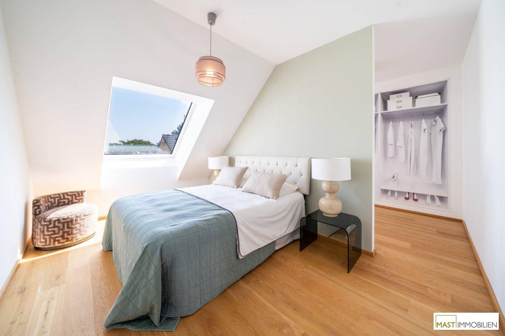 Schlafzimmer mit Dachschräge, Holzboden und integriertem Kleiderschrankbereich.