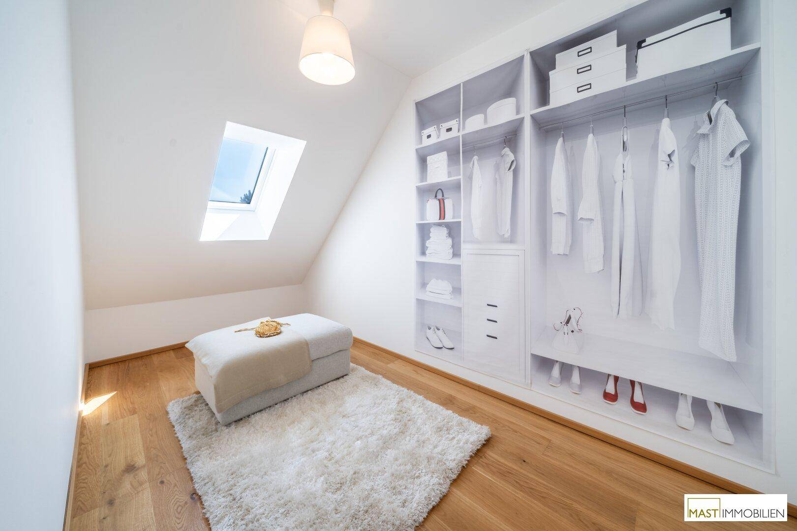 Geräumiger begehbarer Kleiderschrank mit viel Stauraum und Dachfenster.