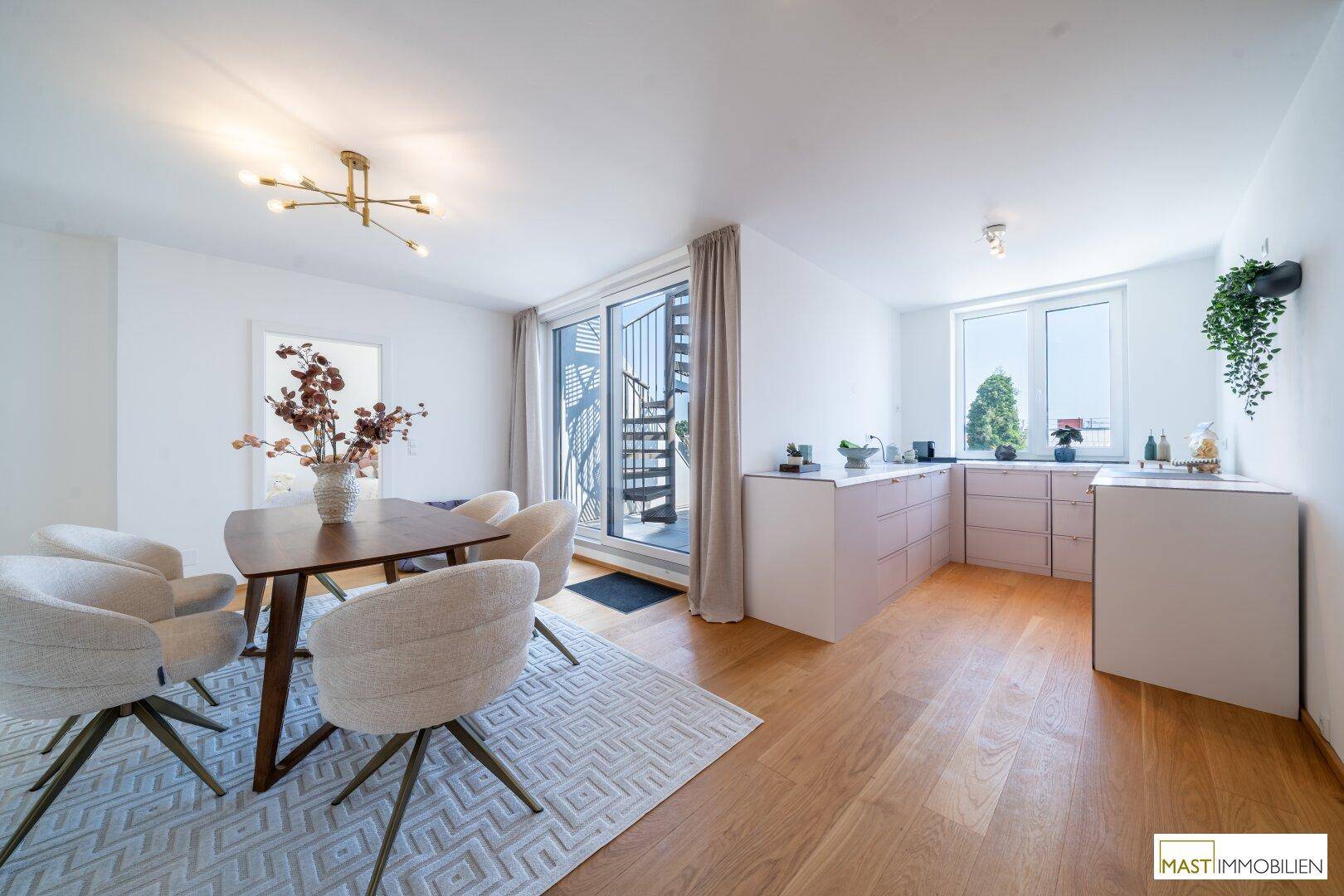 Moderne Küche mit weißen Unterschränken, Holzboden und Essbereich mit Terrassenzugang.