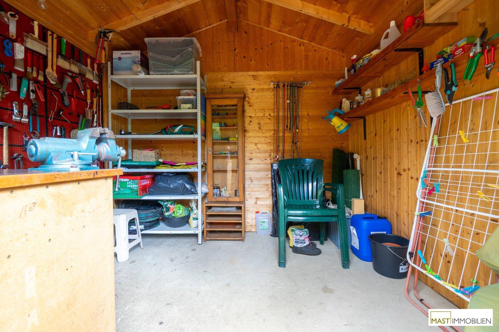 Geräumiger Gartenschuppen mit Werkbank, Regalen und verschiedenen Werkzeugen.