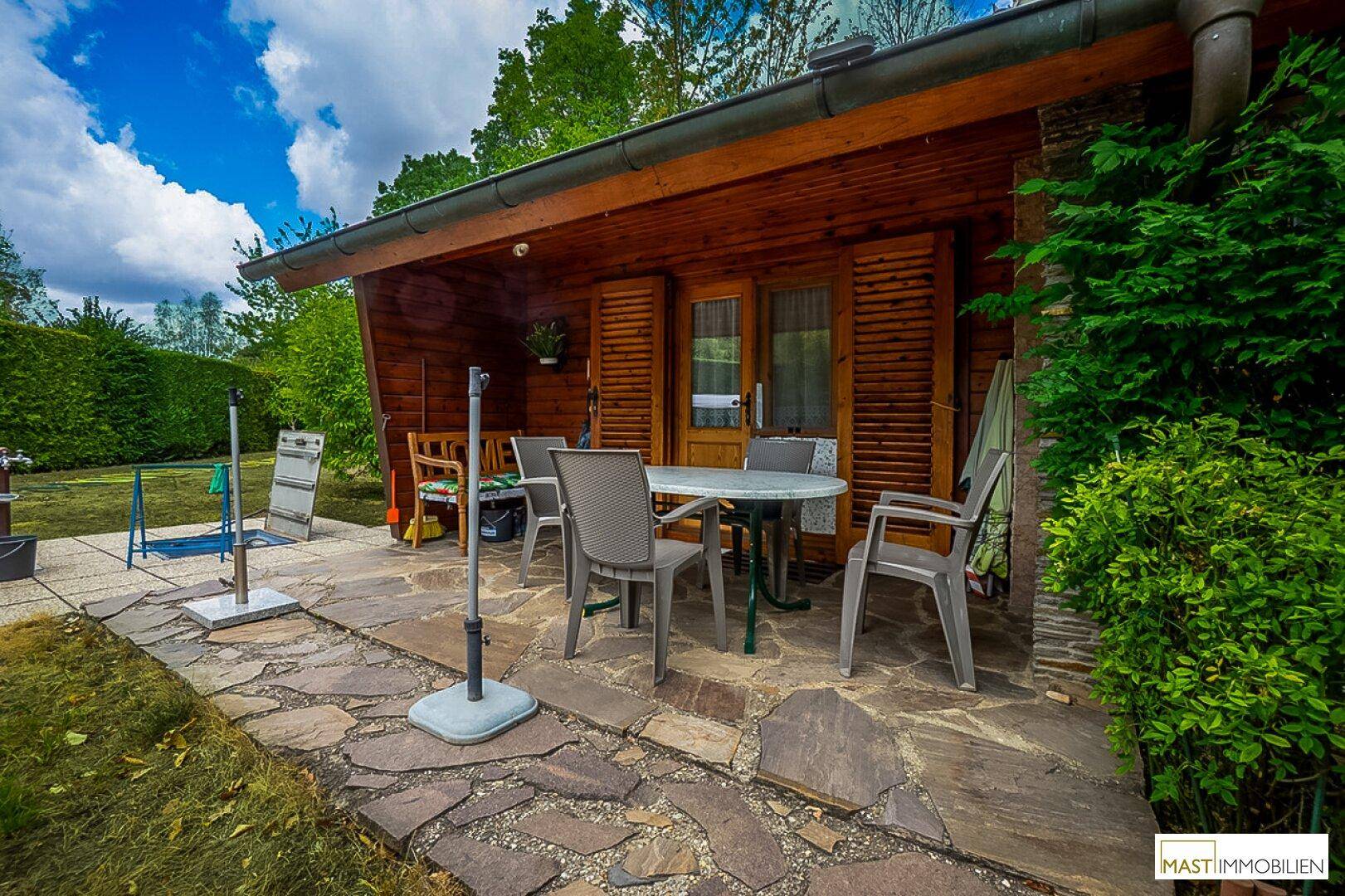 Gemütliche überdachte Terrasse mit Gartenmöbeln, ideal für entspannte Stunden im Freien.