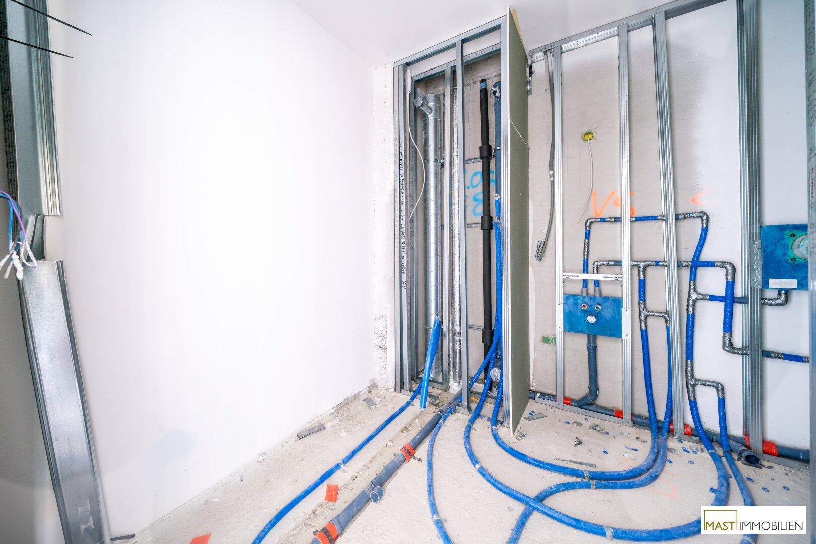 Installationen für Sanitär und Elektrik in einem unfertigen Raum mit Trockenbauwänden.