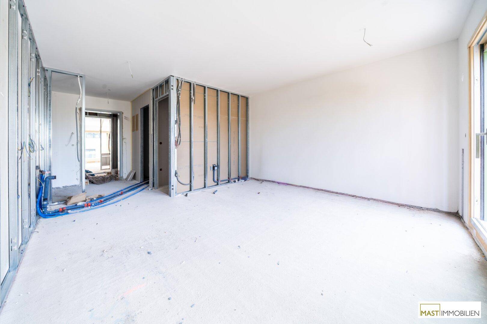 Rohbau eines Raumes mit Metallständern für Trockenbauwände und Betonboden.