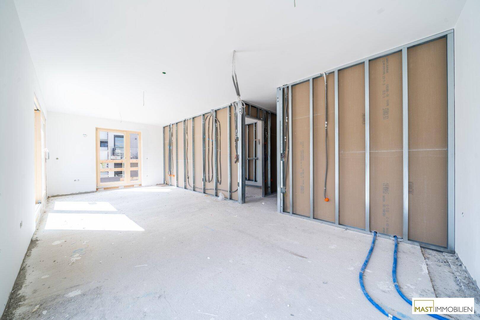 Rohbau-Innenraum mit Metallständern für Trockenbauwände und sichtbaren Installationen.