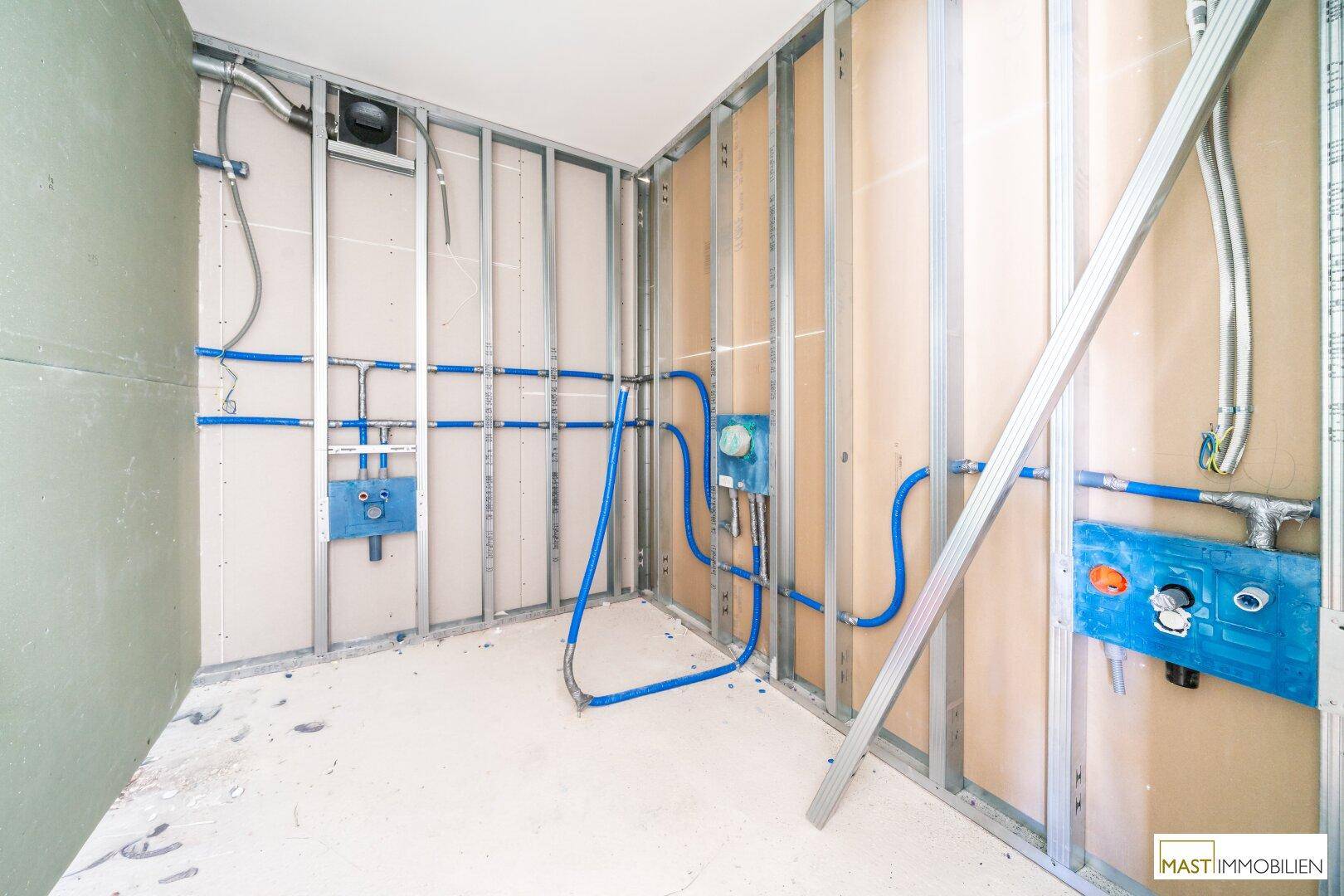 Rohbau eines Badezimmers mit Metallständern und vorbereiteten Sanitärinstallationen.