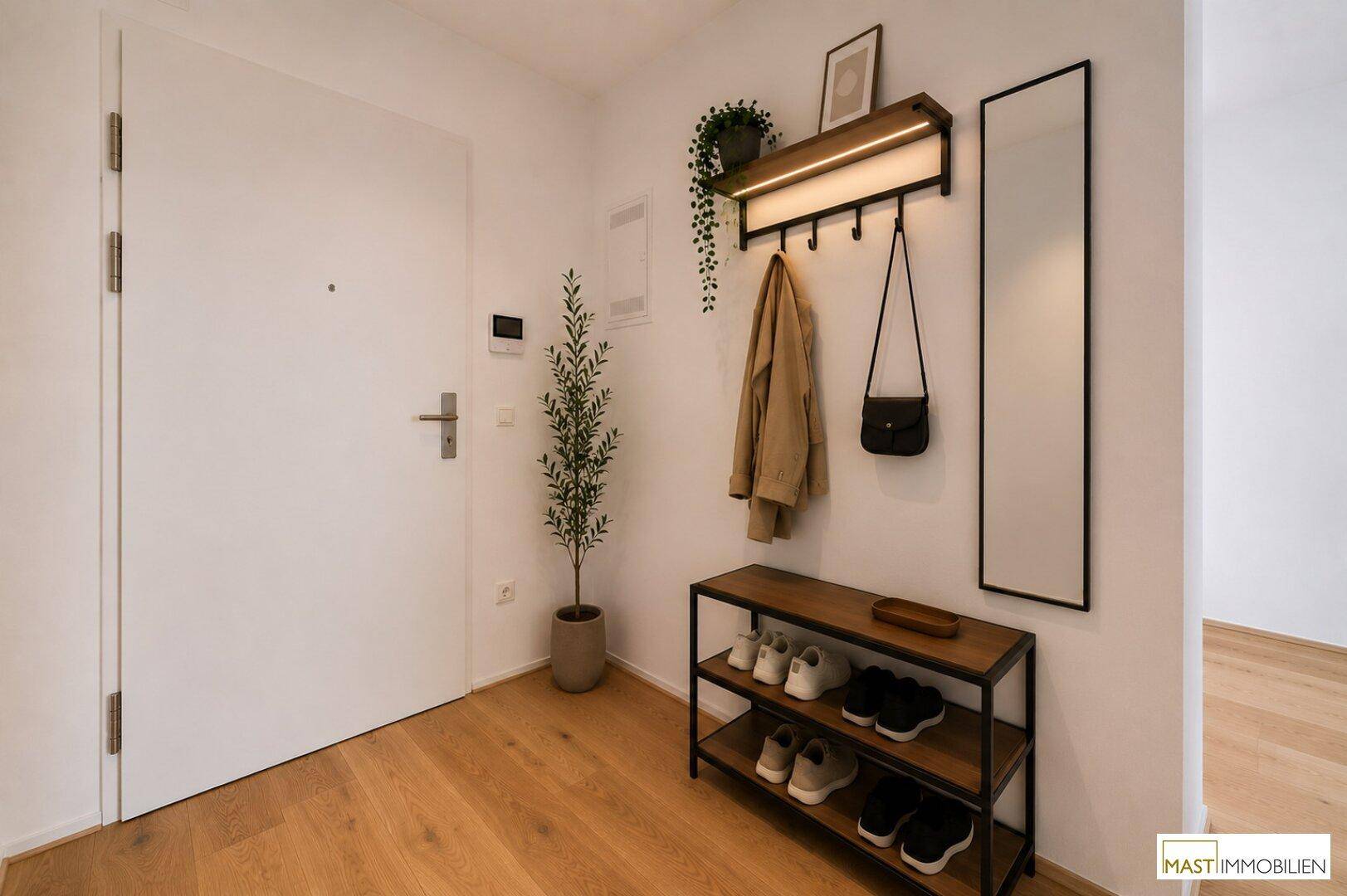 Moderner Eingangsbereich mit Garderobe, Schuhregal und einem hohen Wandspiegel.