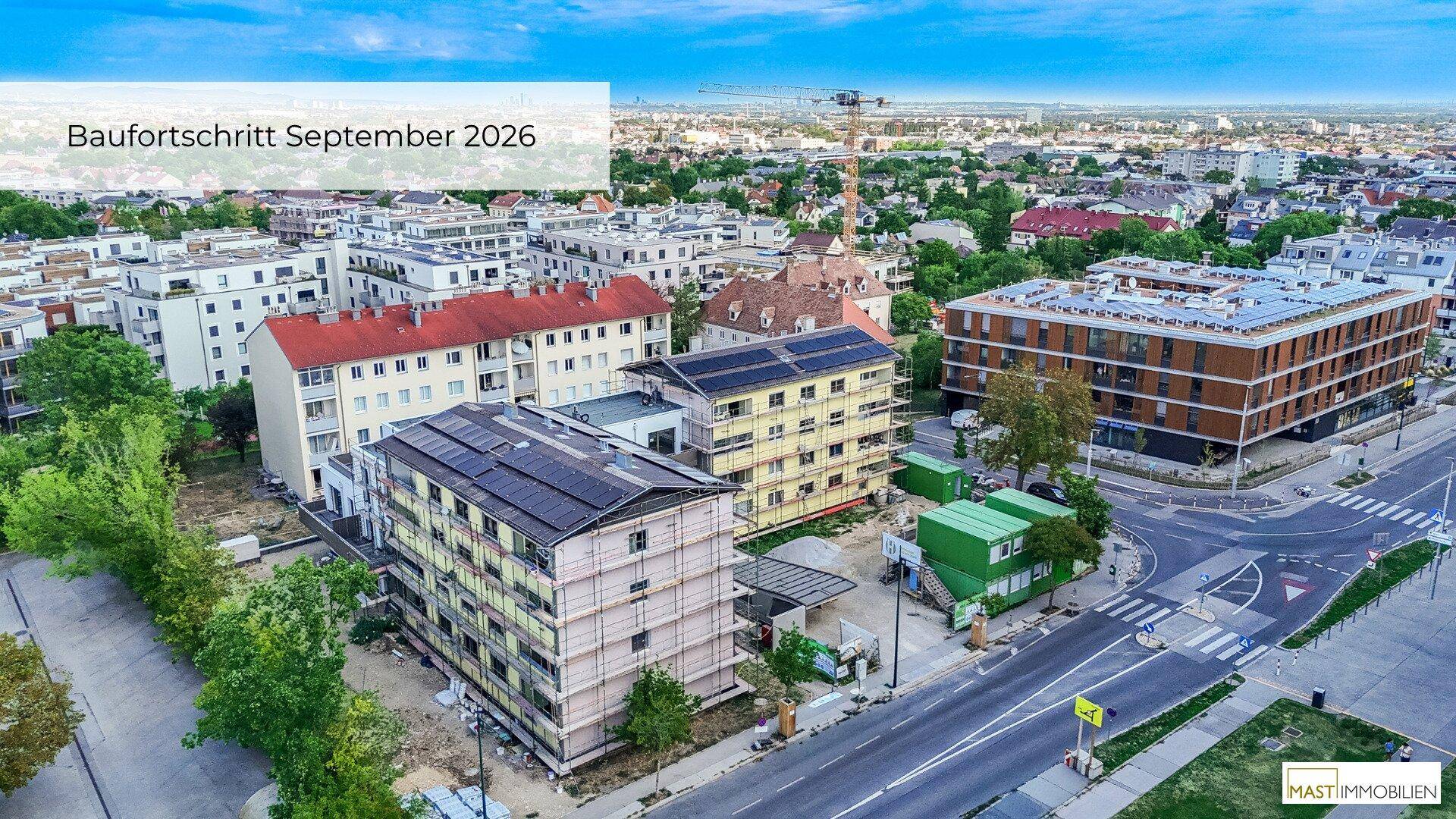 Weitläufige Luftaufnahme des Baufortschritts im September 2026, zeigt städtische Entwicklung und Neubauten.