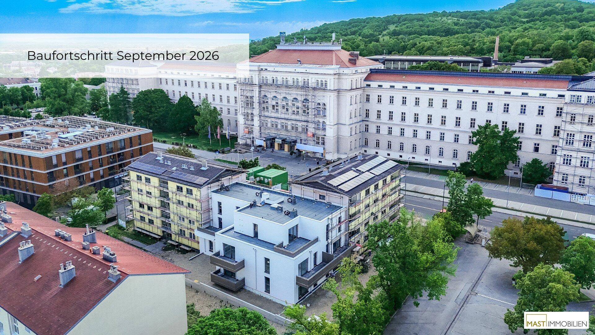 Luftaufnahme des Baufortschritts im September 2026 mit neuen Gebäuden und historischer Architektur im Hintergrund.
