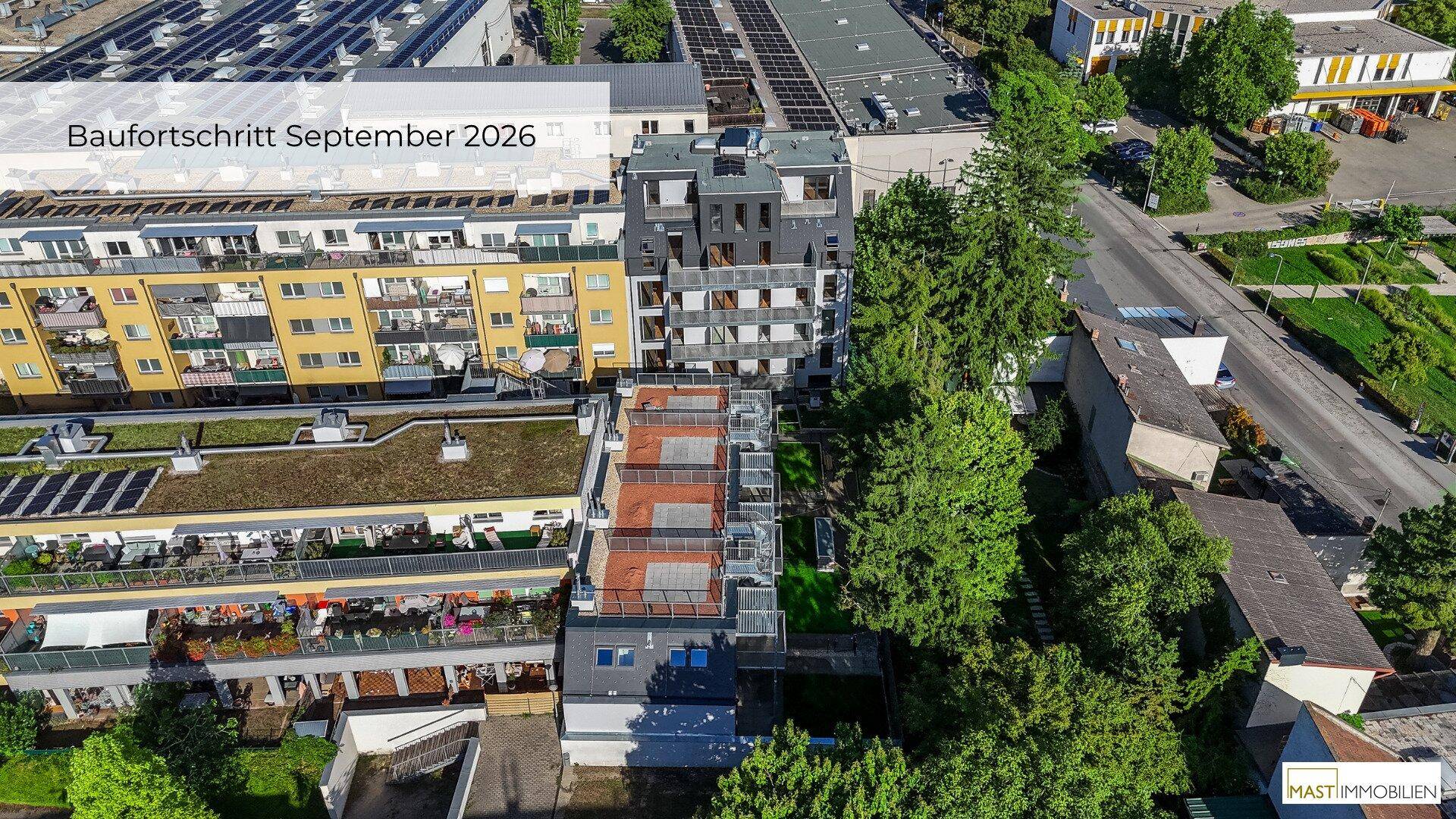 Luftbild eines städtischen Wohnkomplexes mit verschiedenen Gebäudetypen und umliegenden Grünflächen.