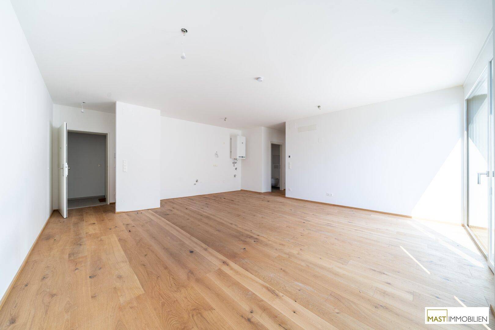 Geräumiger, heller Raum mit Holzboden und weiß gestrichenen Wänden, ideal für individuelle Gestaltung.