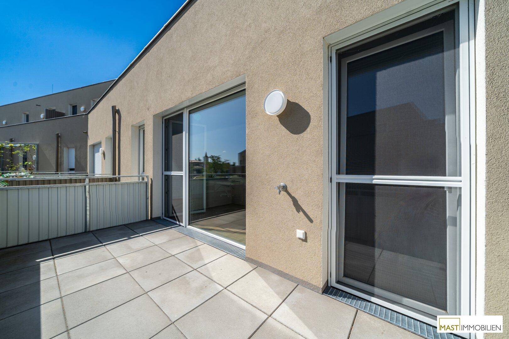 Geräumiger Balkon mit Zugang durch eine große Glasschiebetür, ideal für entspannte Stunden im Freien.