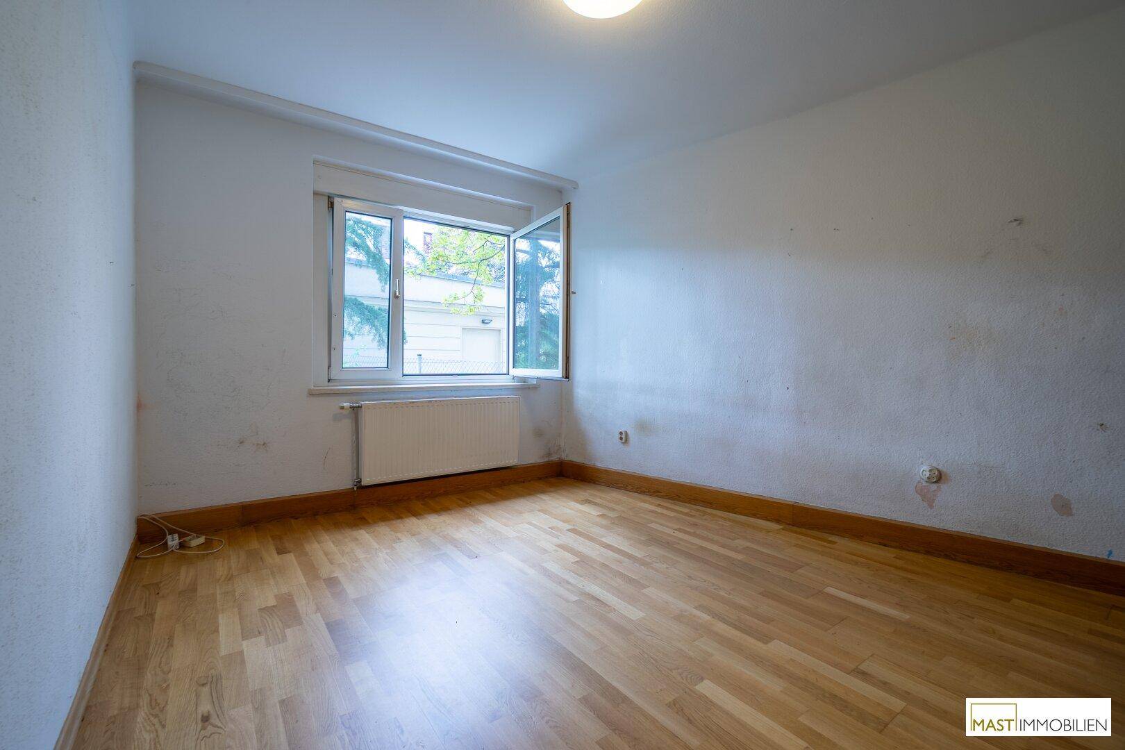 Schlafzimmer mit geöffnetem Fenster für frische Luft und Blick ins Grüne.