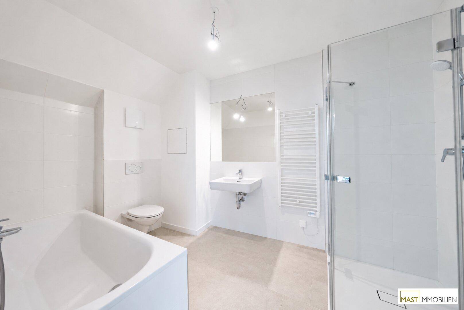 Modernes Badezimmer mit Badewanne, Dusche, WC und beheiztem Handtuchhalter in Weiß.