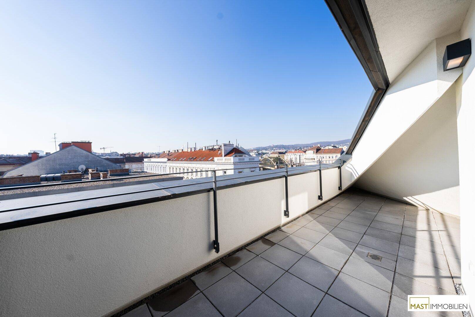 Geräumige Dachterrasse mit Stadtblick und viel Sonne, ideal für Entspannung im Freien.
