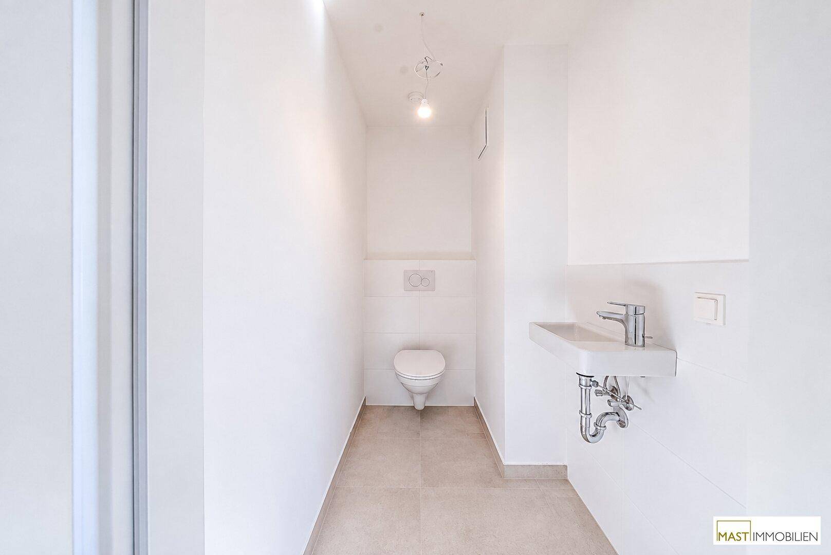 Kleines, modernes Gäste-WC mit Waschbecken und wandhängender Toilette, in schlichtem Design.