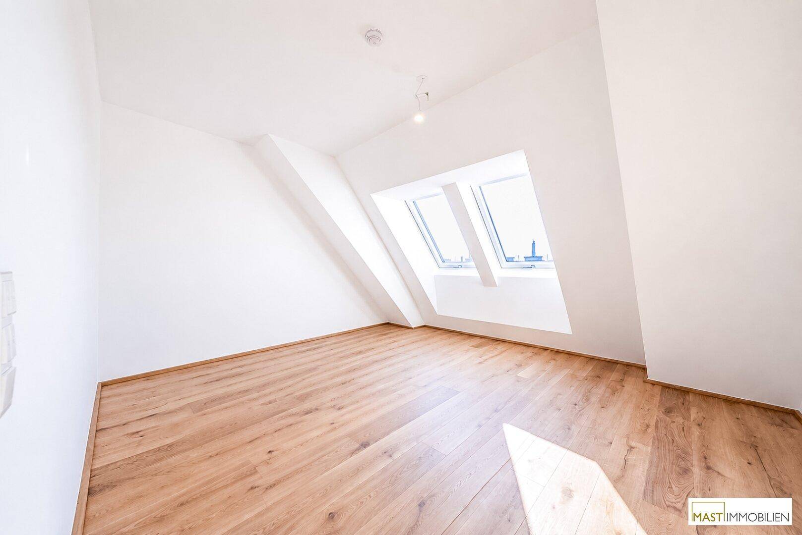 Ruhiges Schlafzimmer im Dachgeschoss mit Holzboden und Dachfenstern, bietet viel Tageslicht.