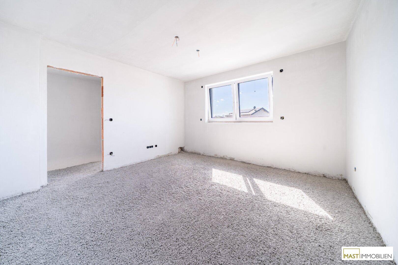Unfertiges Schlafzimmer mit Fenster und viel Tageslicht, ideal für individuelle Gestaltung.
