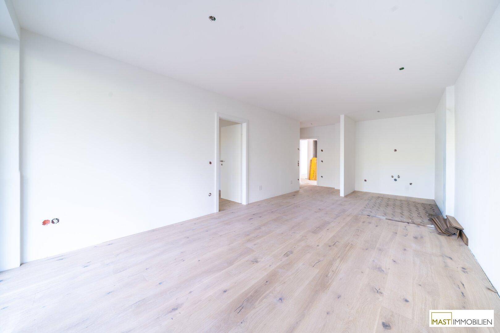 Geräumiger, unmöblierter Innenraum mit hellen Wänden und Holzboden, ideal für individuelle Gestaltung.