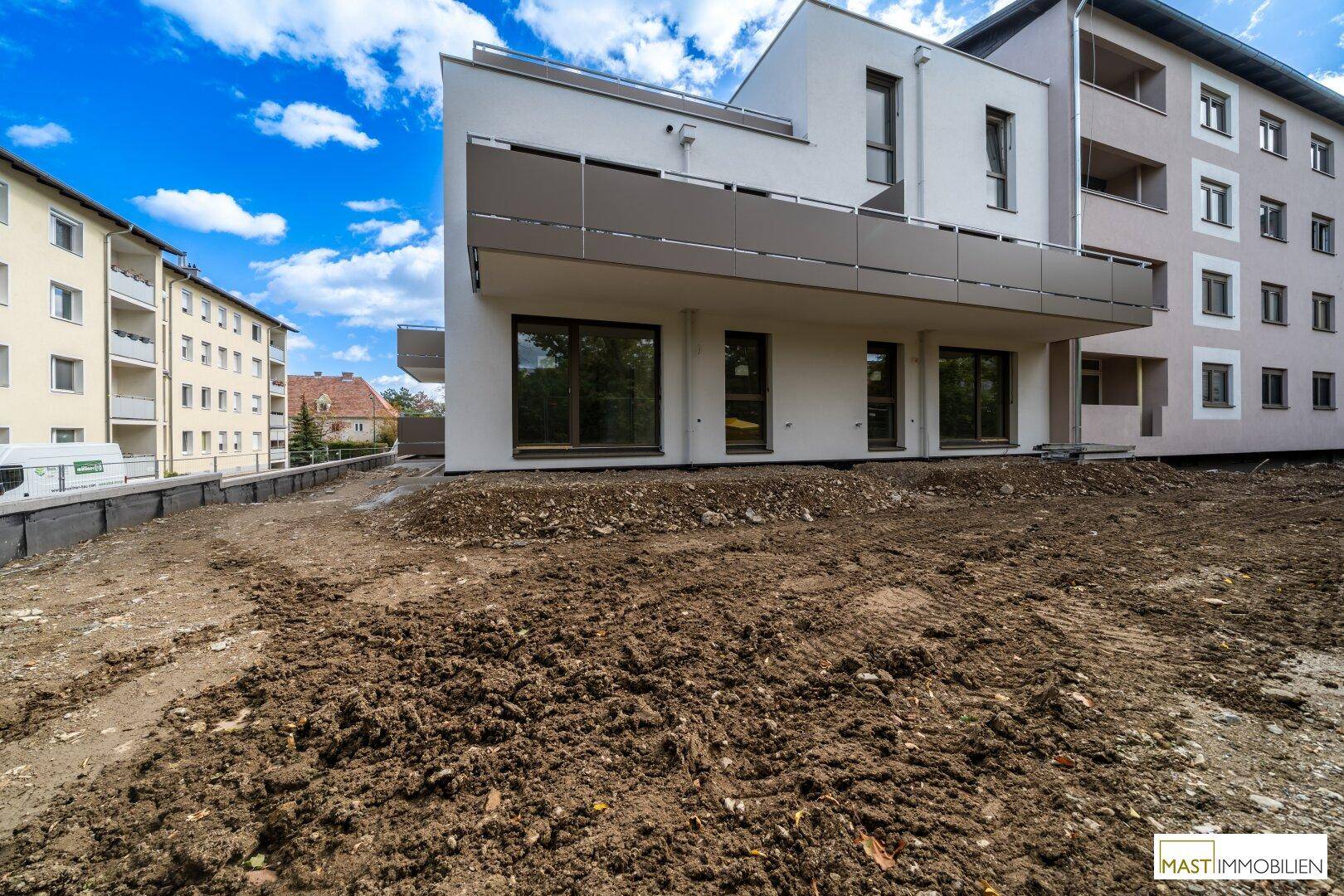 Neubau mit moderner Architektur, großen Fenstern und unfertigem Außenbereich.