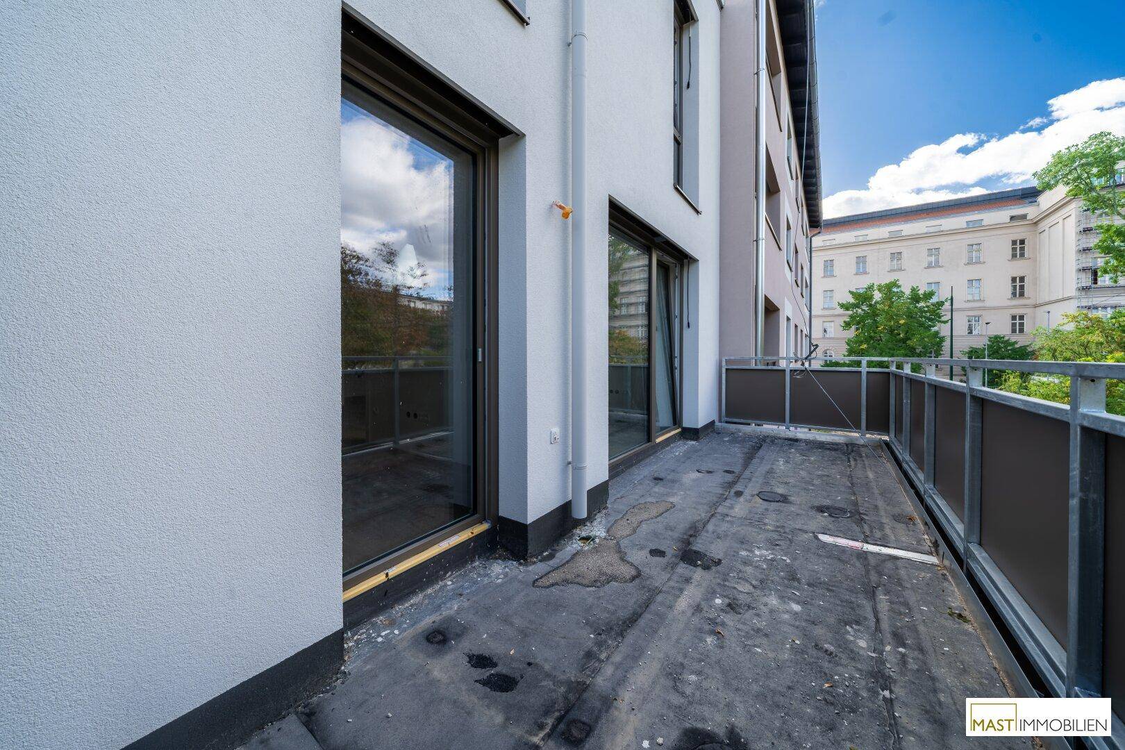 Langer Balkon mit Zugang von mehreren Zimmern und Blick auf die Umgebung.