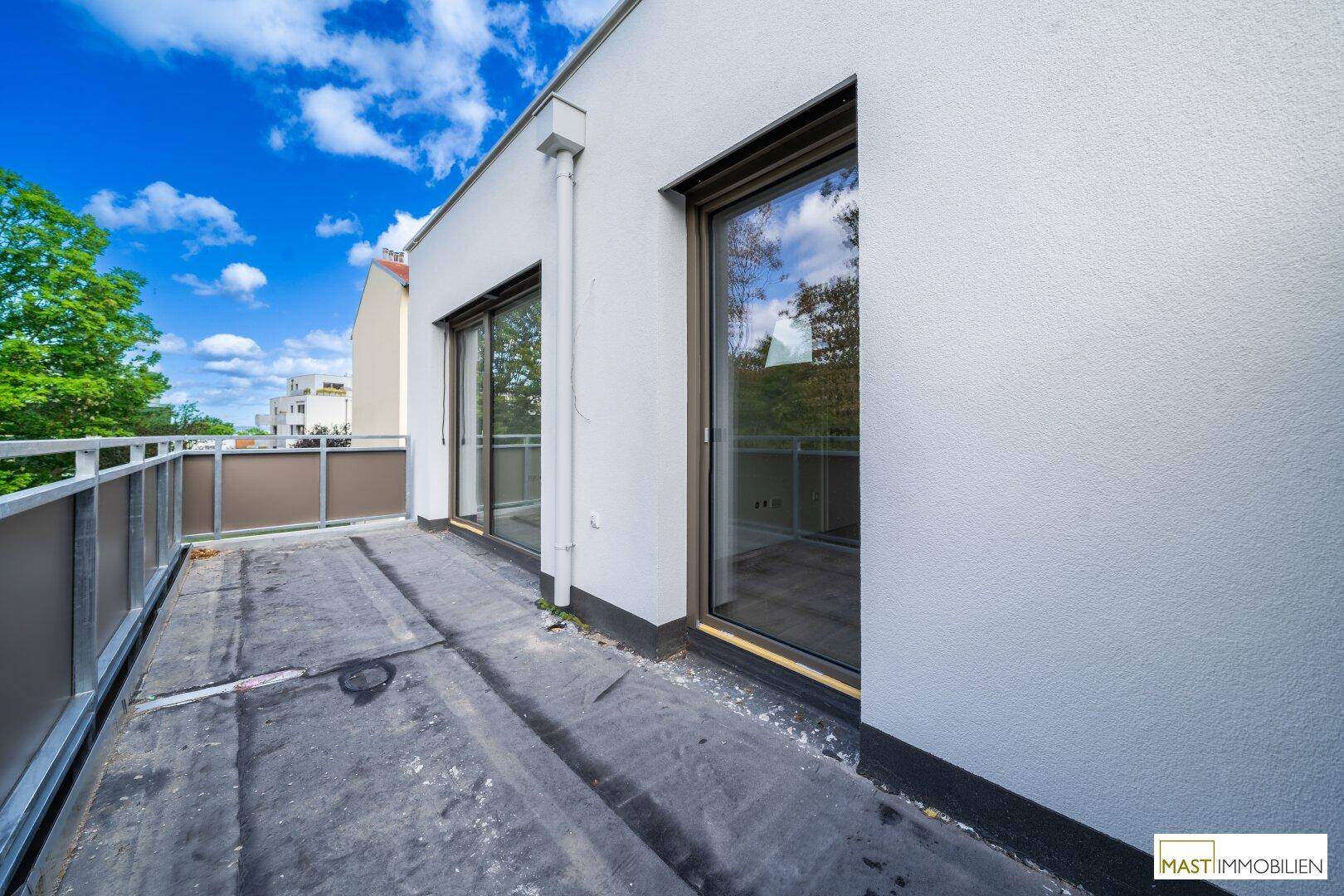 Großer Balkon mit Zugang von Innenräumen und Blick auf die Umgebung.