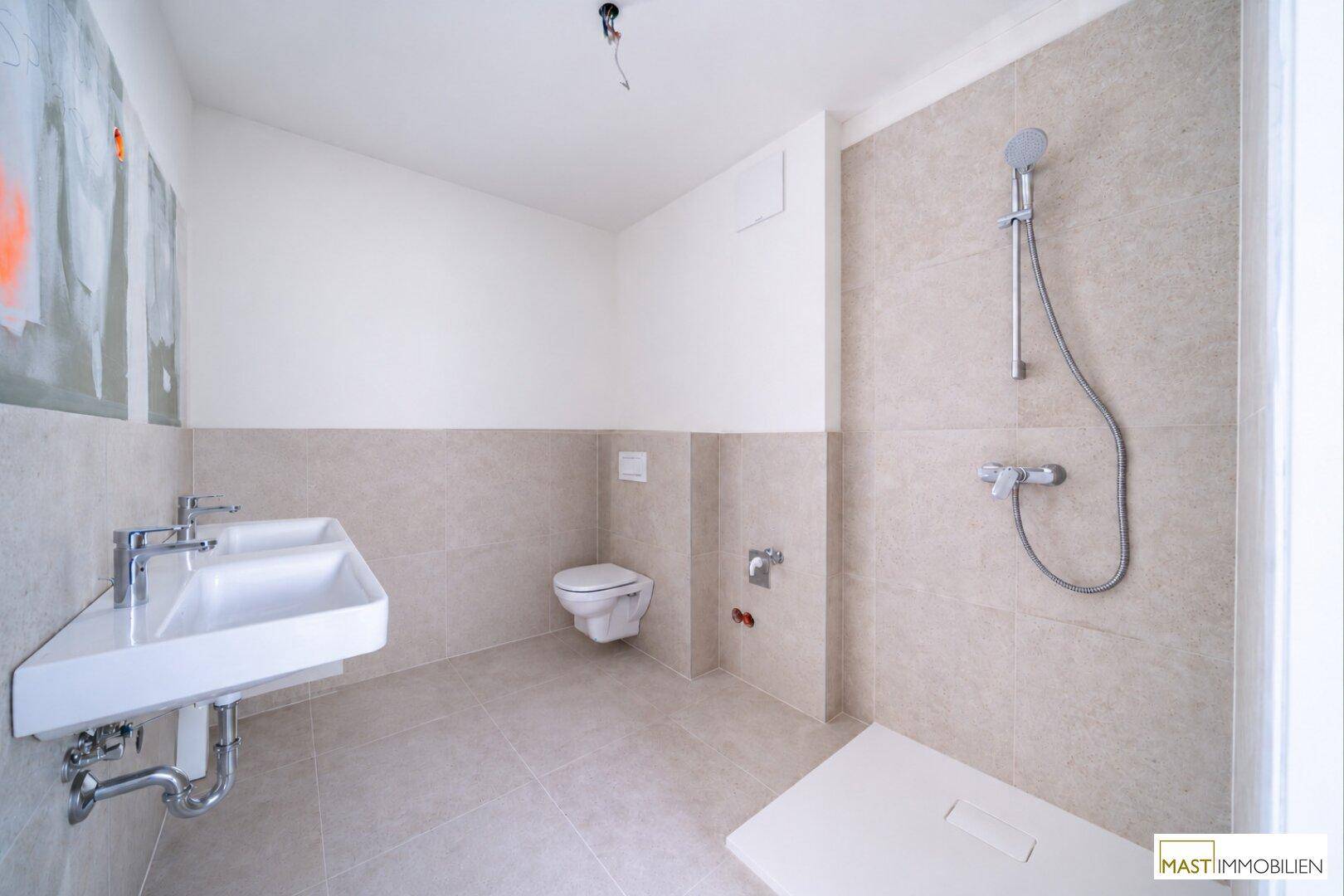Modernes Badezimmer mit Doppelwaschbecken, Toilette und Duschbereich.