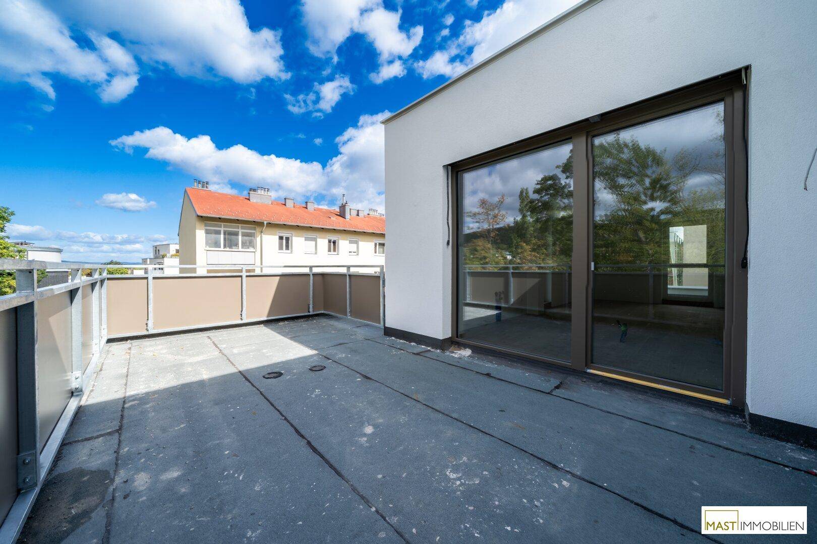 Geräumige Terrasse mit Schiebetüren, die direkten Zugang zum Innenbereich bieten und viel Licht hereinlassen.