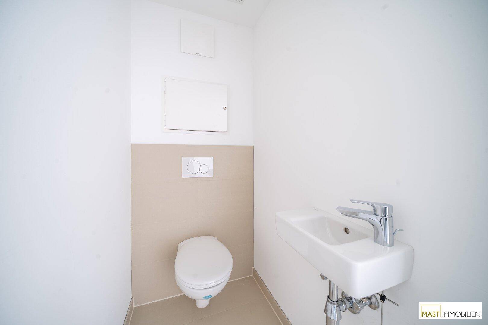 Kleines Gäste-WC mit wandhängender Toilette und modernem Waschbecken, sehr gepflegt.