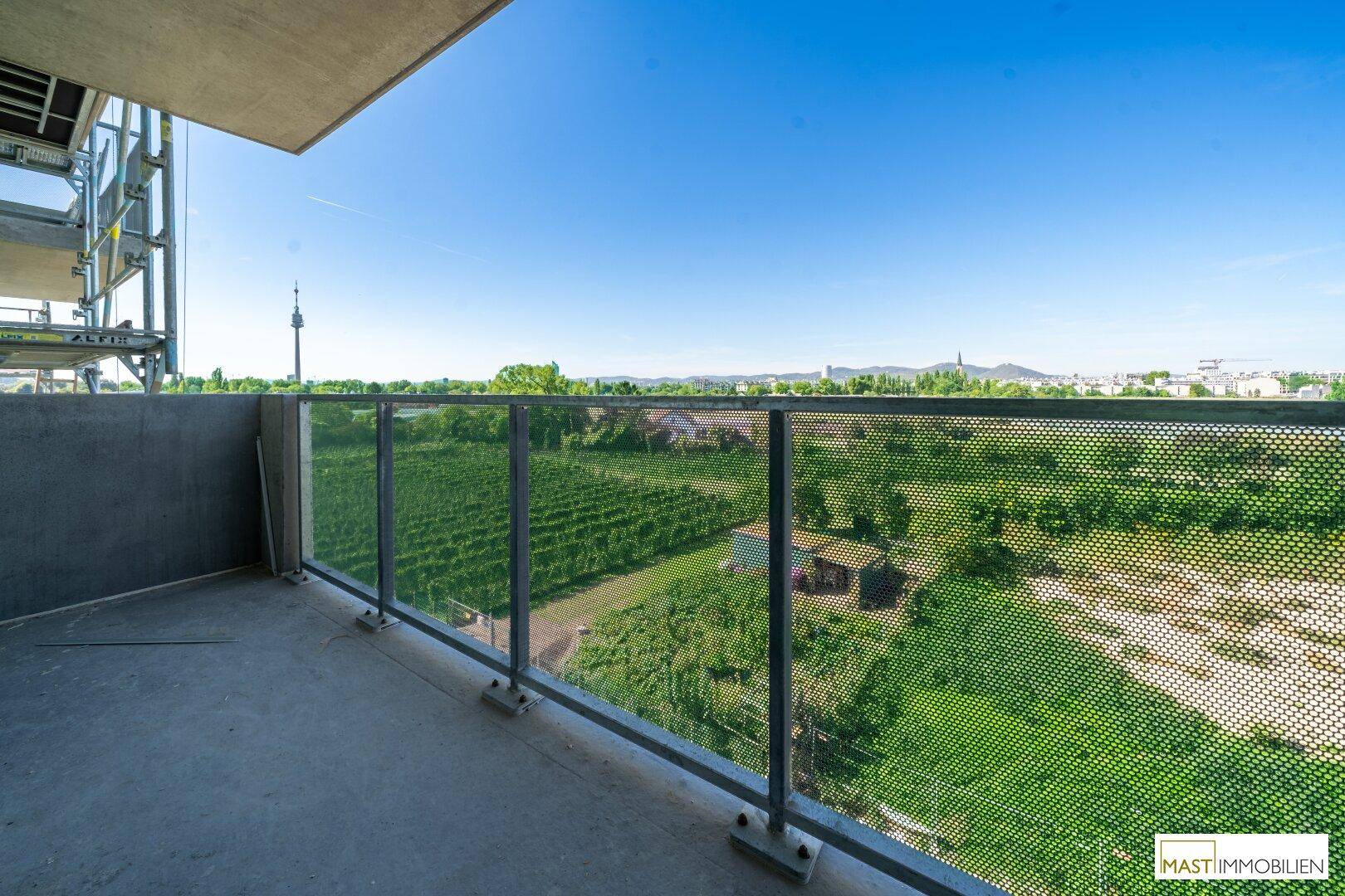 Balkon mit Glasgeländer und weitem Blick über Weinberge und die Stadt, ideal zum Entspannen.